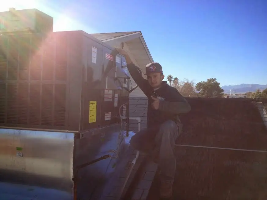 HVAC technician performing AC Tune-Up on a rooftop unit in Cincinnati